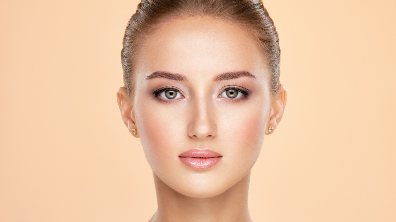 Model with flawless complexion wearing Teint Naturelle Foundation. Radiant, lightweight base enhances natural beauty.