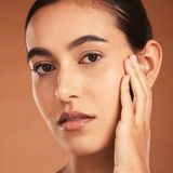 Model with warm skin tone showcasing Teint Naturelle Foundation. Enhances complexion with breathable formula.