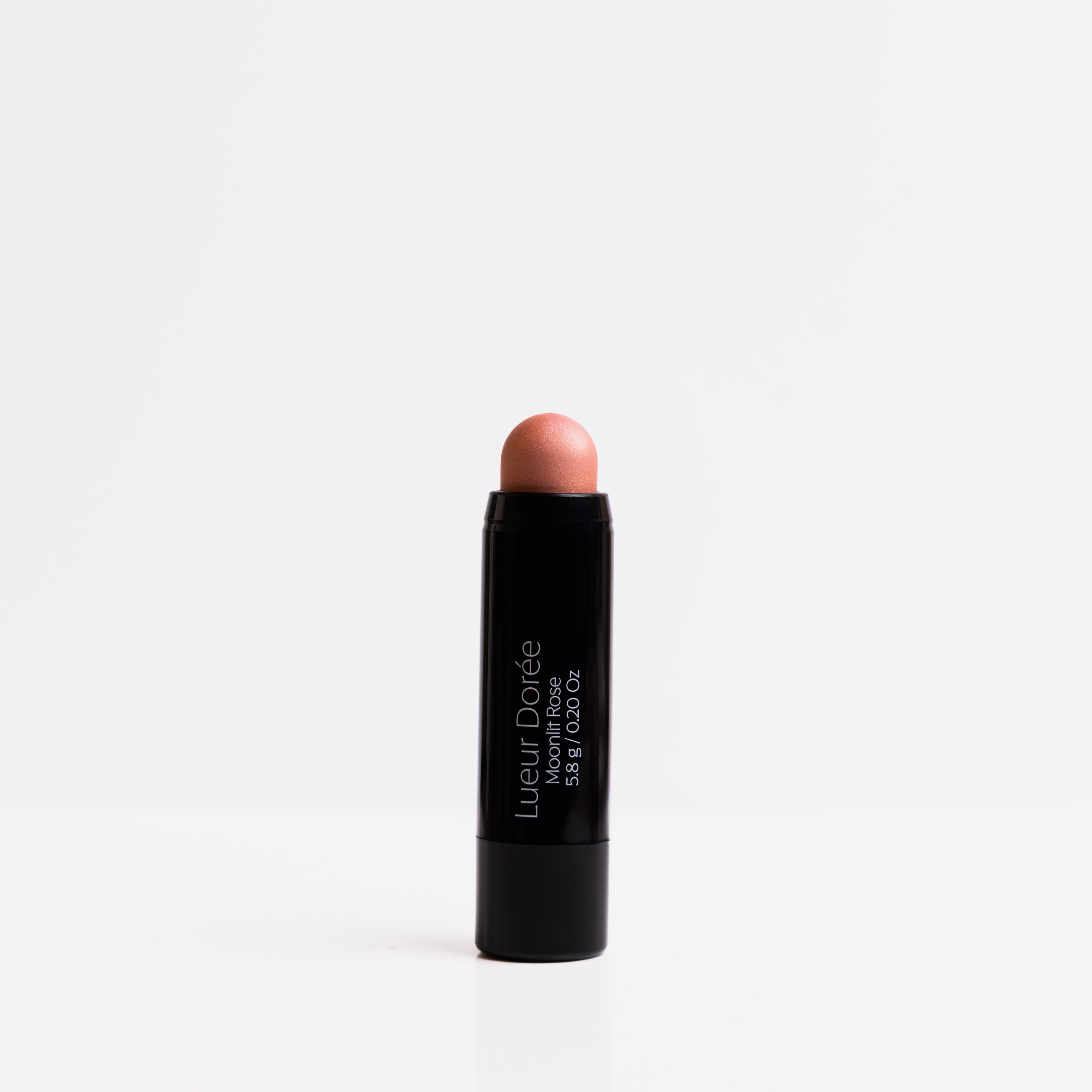 Lueur Dorée Moonlit Rose highlighter stick with creamy rose-gold tip, ideal for soft-focus glow on mature skin.
