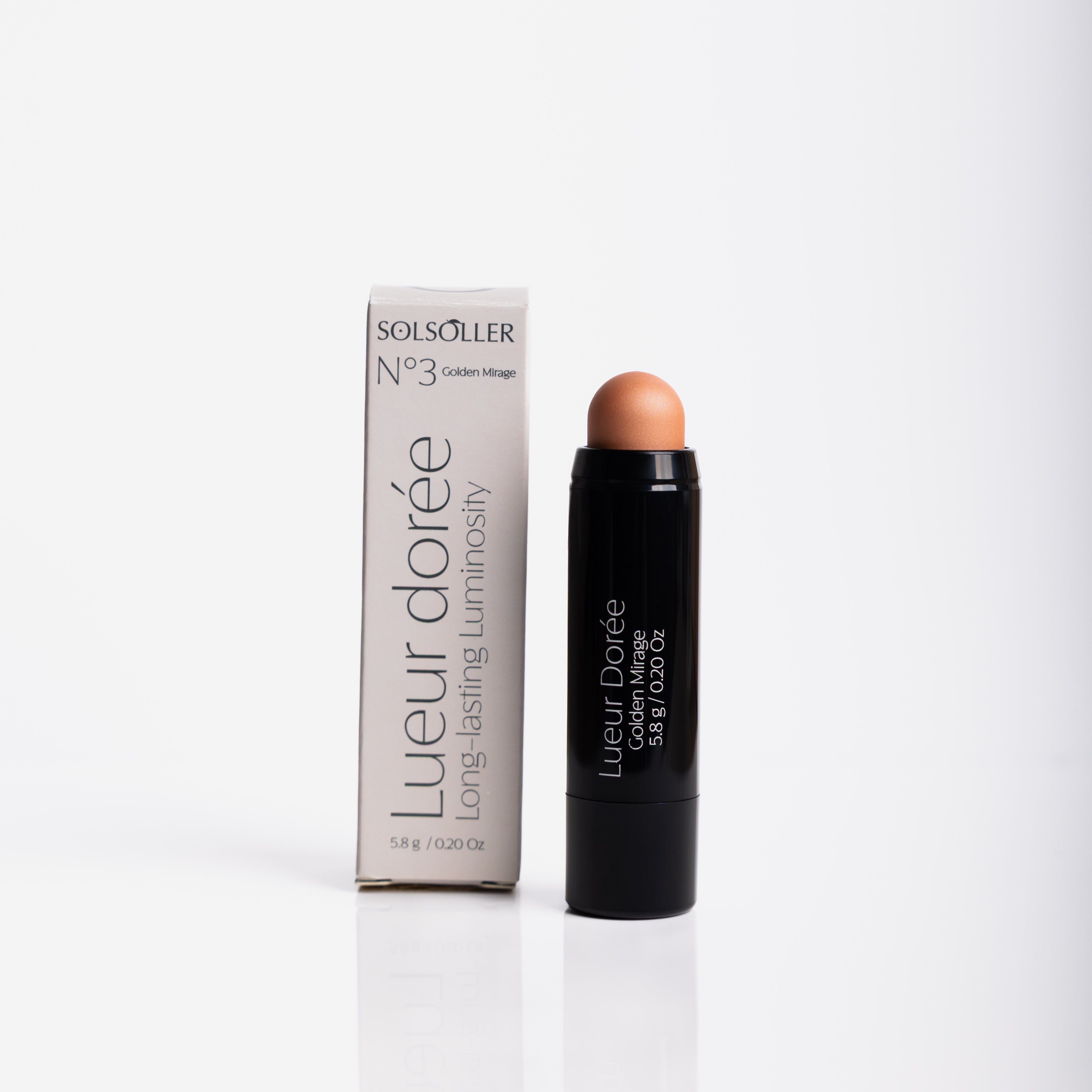 Lueur Dorée Highlighter Stick in Golden Mirage with packaging, offering waterproof, creamy formula for radiant glow.