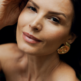 Model with smooth, radiant skin wearing L’Marcela Setting Powder, demonstrating its lightweight, natural matte effect on the face.
