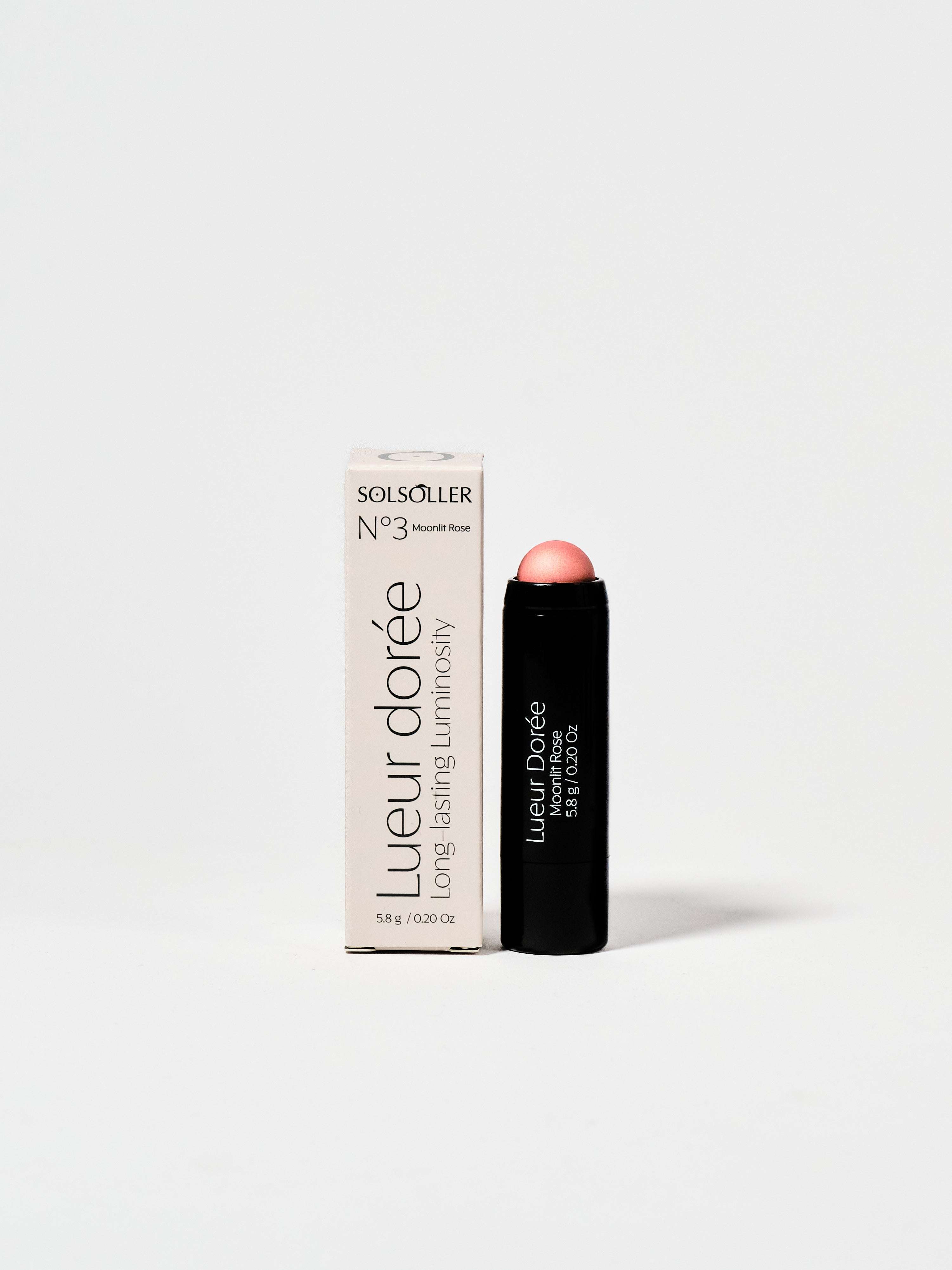 Moonlit Rose - Champagne Rose Highlighter in sleek black stick packaging with box, offering radiant glow and 13hr wear for face makeup.