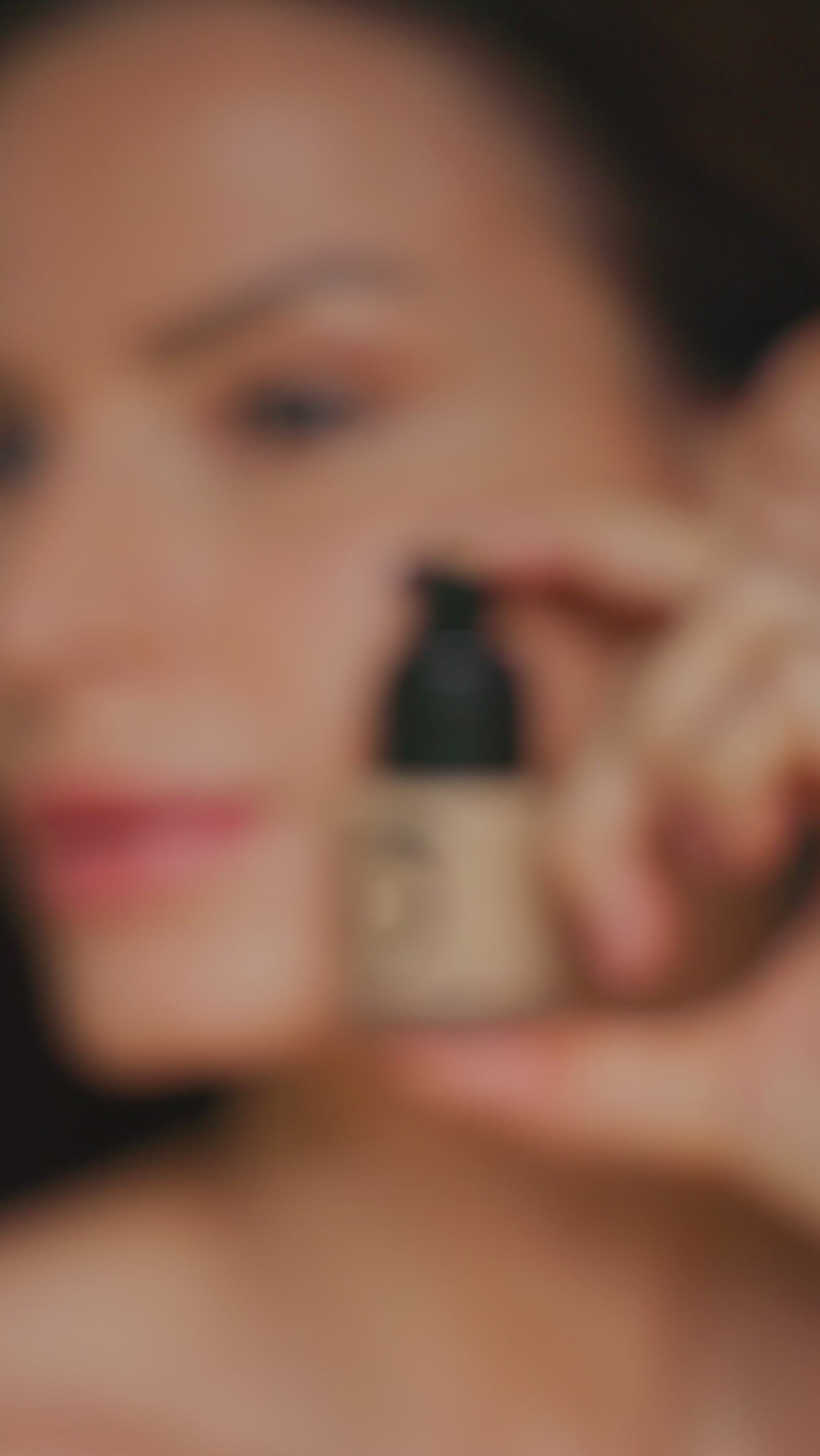 Blurred image of person holding Teint Naturelle Foundation. Focus on product's compact, elegant design.